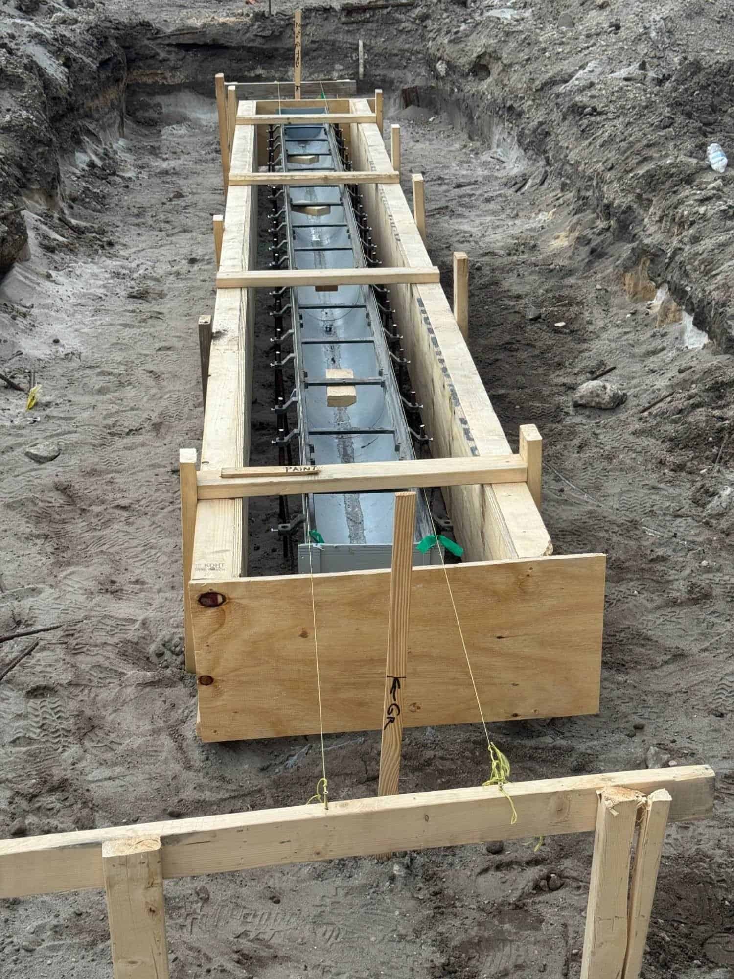 Trench drain set to grade with string lines and batter boards before the concrete pour in West Palm Beach, FL