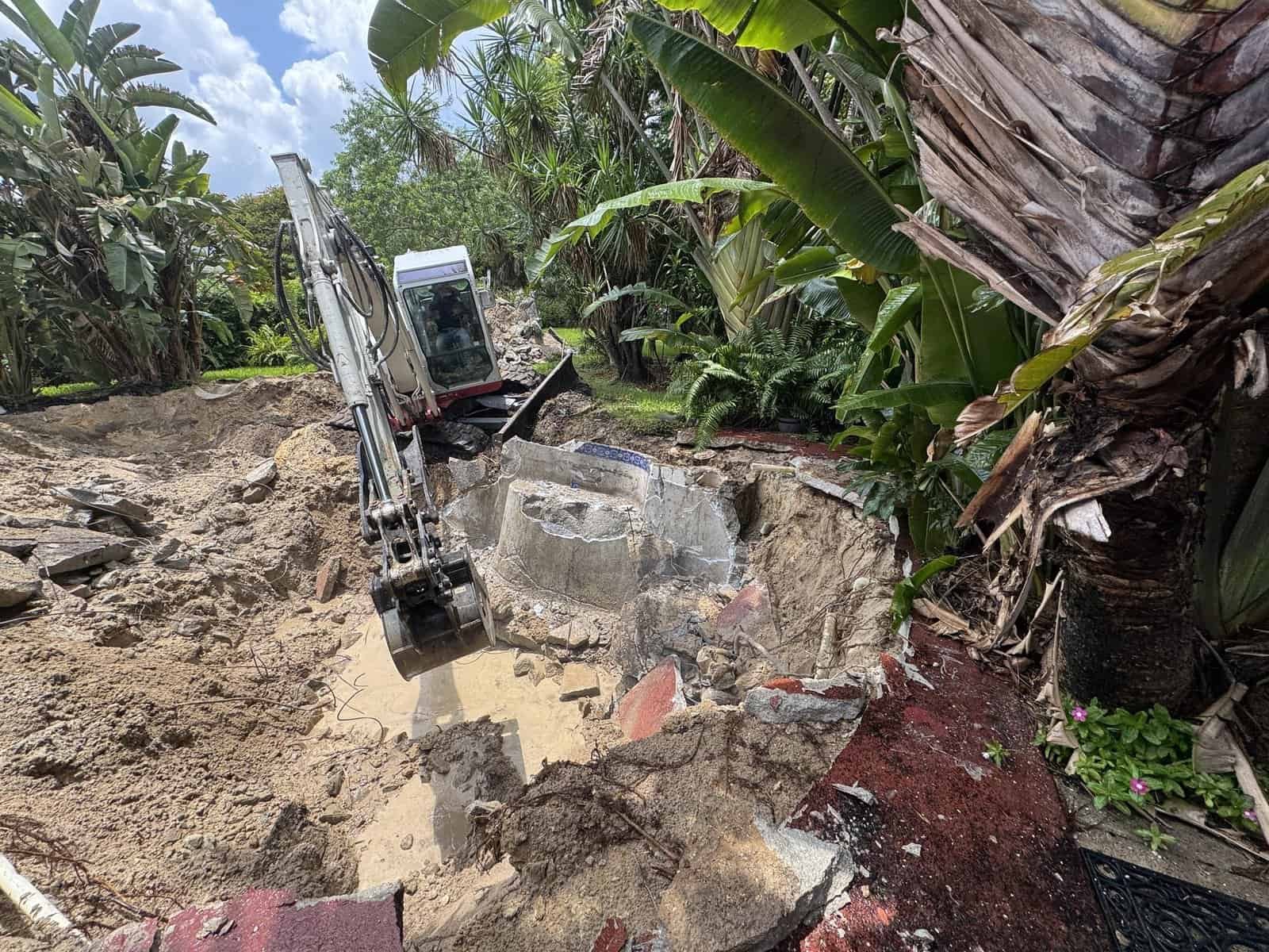 Removing the broken concrete pool structure during swimming pool removal in Royal Palm Beach, FL