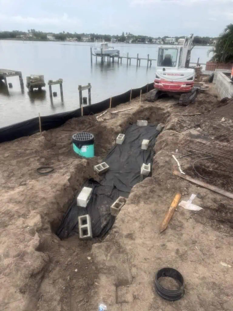 Nyloplast drain basin with grate and exfiltration trench along intracoastal Tequesta FL